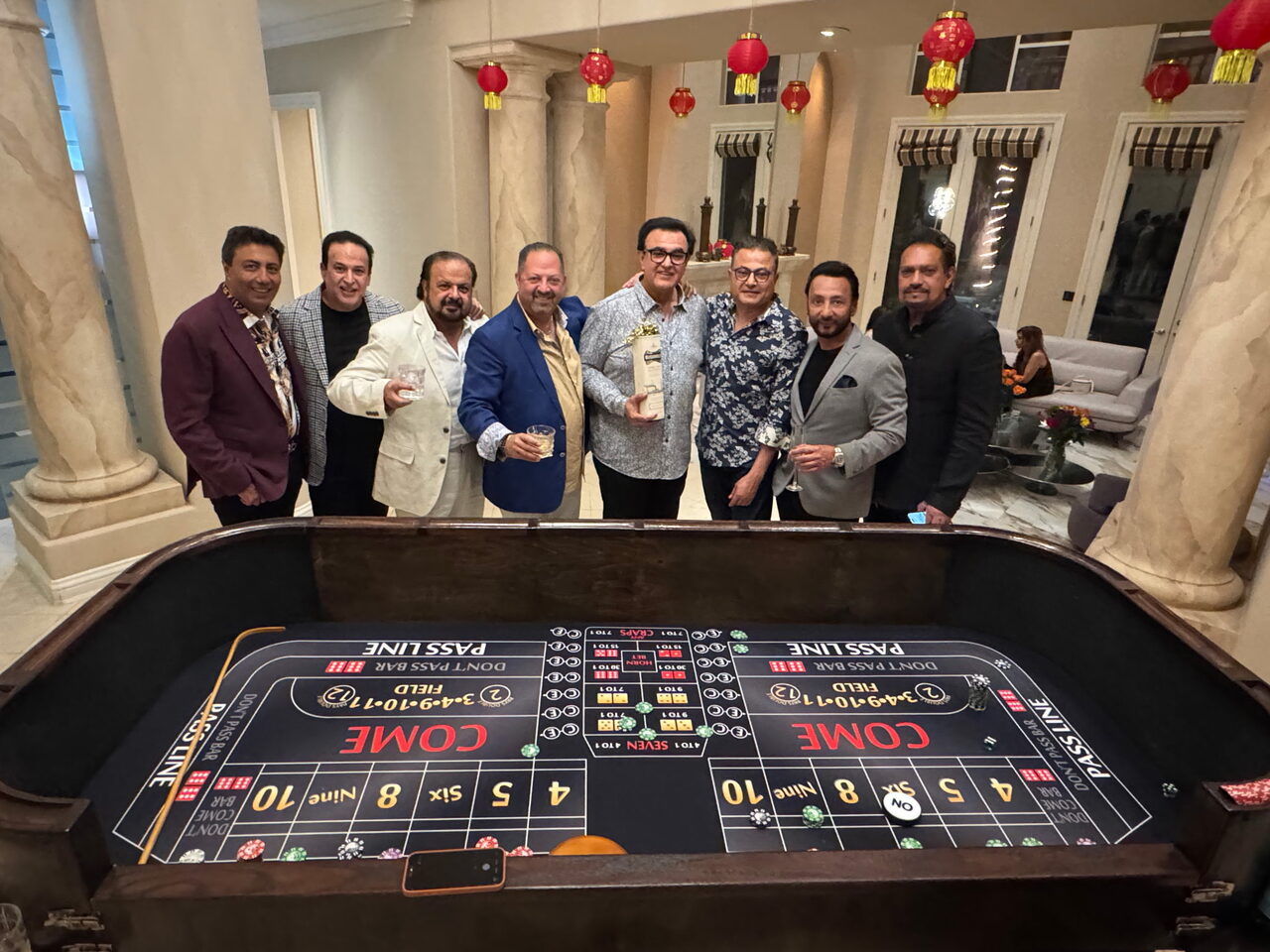 Friends celebrating around a craps table at a Park City chalet casino party