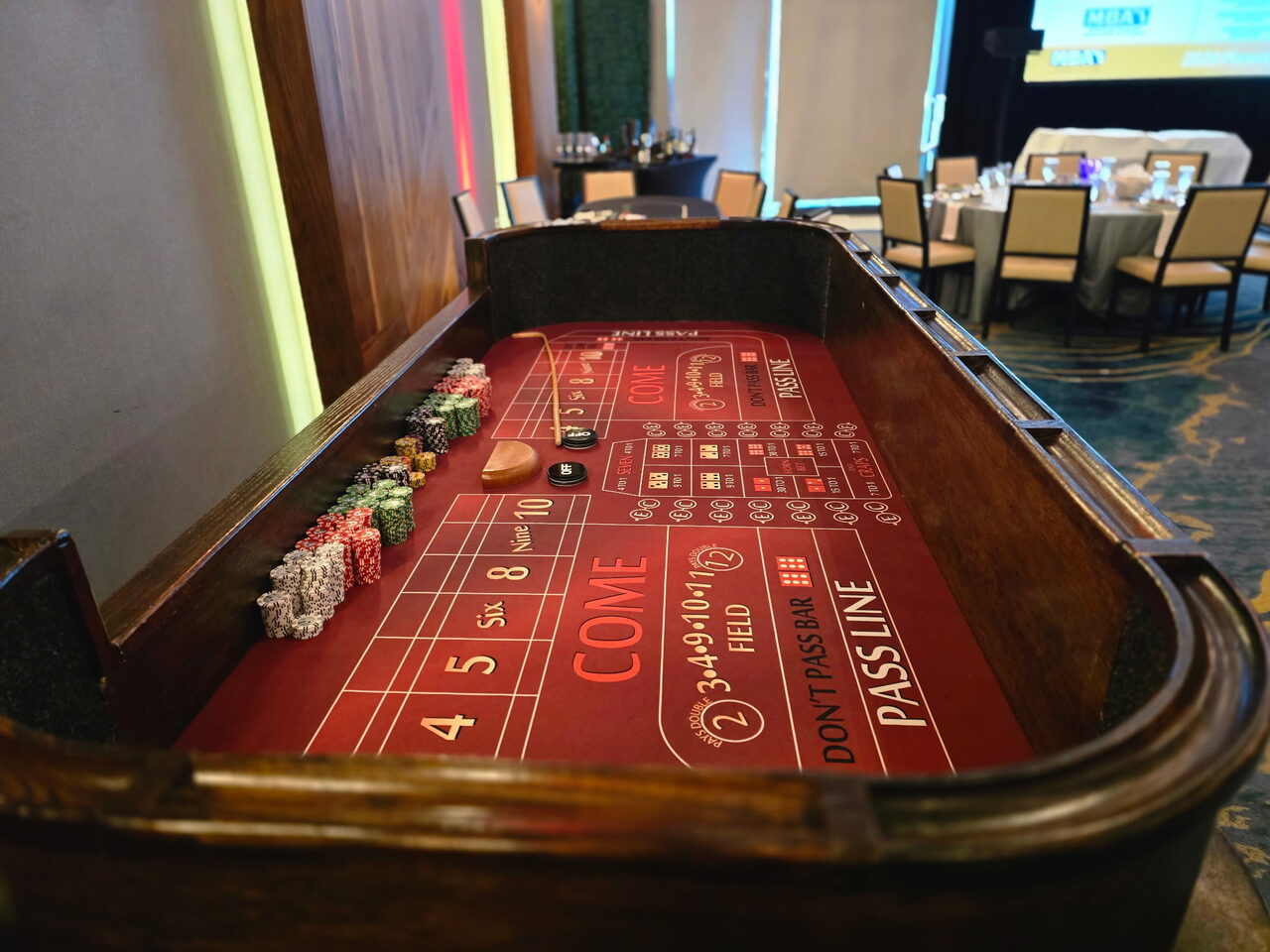 Red-felt craps table with a chip rail at a Salt Lake City corporate casino night